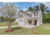 Charming two-story home featuring a covered entryway, attached garage, and well-maintained landscaping at 113 Winding Path Dr., Loris, SC 29569