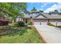 Charming brick home featuring a well-manicured lawn, attached garages, and inviting curb appeal at 115 Harbor Club Dr. # 4A, Pawleys Island, SC 29585