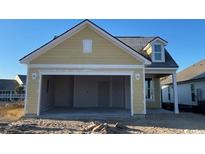 A spacious two-car garage with plenty of room for parking and storage in a new construction yellow home at 1209 Lady Bird Way, North Myrtle Beach, SC 29582
