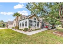 Bright sunroom addition featuring many windows with stone and tan siding at 145 Stonegate Blvd. # 145, Murrells Inlet, SC 29576