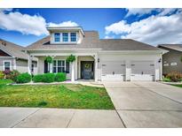 Charming home featuring a two-car garage, manicured lawn, and inviting front porch at 168 Zostera Dr., Little River, SC 29566