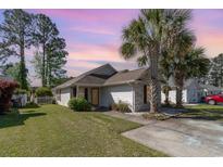 Single-story home with a well-manicured lawn and driveway, enhanced by mature trees on a partially clouded sky at 174 Sussex Ct., Longs, SC 29568