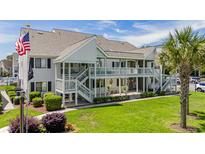 Inviting condo complex featuring a two-story building, well-maintained landscaping, and a communal pool at 1880 Auburn Ln. # 27 A, Surfside Beach, SC 29575