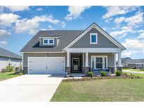 Charming home featuring a manicured lawn, attached garage and inviting front porch with seating at 2013 Santa Maria St., Myrtle Beach, SC 29579