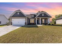 Charming single-Gathering home with a two-car garage and well-manicured lawn under a colorful sky at 204 Palmetto Sand Loop, Conway, SC 29527