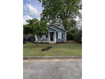 Charming home with a welcoming front porch, complemented by mature trees and a well-maintained lawn at 211 Amber Dr., Marion, SC 29571