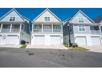 Charming beach home with white garage doors and a cozy second story porch at 220 Gloucester Way, Little River, SC 29566