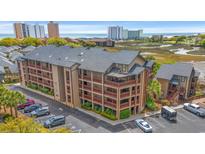 Beautiful condo building featuring private balconies, lush landscaping, and plenty of parking with ocean views at 223 Maison Dr. # F-12, Myrtle Beach, SC 29572