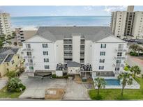 An aerial shot of a white condo building with blue shutters, a pool, and beach access at 2406 S Ocean Blvd. # 301, North Myrtle Beach, SC 29582