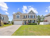 Charming two-story home boasts a well-manicured lawn, inviting entrance, and attached two car garage at 3212 Saddlewood Circle, Myrtle Beach, SC 29579