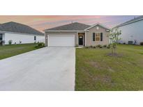 Charming single-story home with a well-manicured lawn and a spacious two-car garage at 376 Black Pearl Way, Myrtle Beach, SC 29588