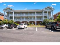 Three-story condo building featuring multi-level balconies and well-maintained landscaping at 3943 Gladiola Ct. # 202, Myrtle Beach, SC 29588