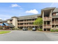 A spacious condo building featuring multi-level balconies and a convenient parking area at 410 Melrose Pl. # 110, Myrtle Beach, SC 29572