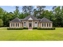 Charming brick home featuring manicured lawn, trimmed hedges, and symmetrical architectural details at 4100 Hagwood Circle, Conway, SC 29526