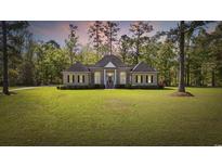 Charming brick home with lush lawn, mature trees, and manicured shrubbery at 4100 Hagwood Circle, Conway, SC 29526