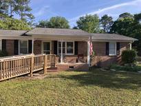 Charming single-story brick home with a front yard, ramp, and cozy porch seating at 4204 Peachtree Ln., Myrtle Beach, SC 29588