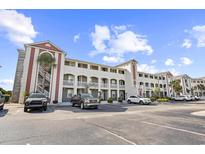 Spacious condominium building with ample parking and lovely landscaping under a beautiful blue sky at 4518 N Planatation Harbour Dr. # G-17, Little River, SC 29566