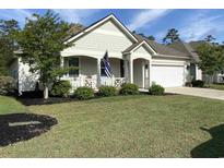 Charming single-Gathering home featuring a well-manicured lawn, covered porch, and attached two-car garage at 505 Heartland Ct., Murrells Inlet, SC 29576