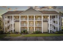 Attractive condo building with a well-kept lawn, multiple stories, balconies, and welcoming front doors at 5882 Longwood Dr. # 201, Murrells Inlet, SC 29576