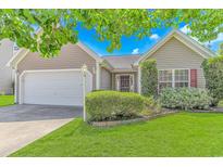 Charming home featuring manicured lawn, lush shrubs, and a welcoming two-car garage at 6000 Isabel Ct., Myrtle Beach, SC 29579