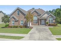 Charming brick home featuring a well-manicured front yard with lush greenery and a welcoming driveway at 610 Cocas Dr., Myrtle Beach, SC 29579