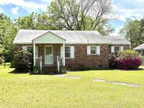 Charming single-story brick home with a metal roof and a well-maintained front yard at 701 Martin Luther King Dr., Andrews, SC 29510
