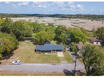Stunning aerial view of waterfront home with lush landscaping and a serene pond in a quiet neighborhood at 391 Waterford Dr., Georgetown, SC 29440