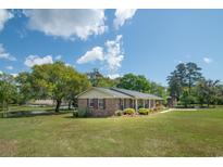 Lovely brick ranch home with mature landscaping and a view of the serene pond at 391 Waterford Dr., Georgetown, SC 29440