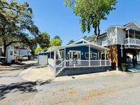 Charming blue beach house with a white picket fence and covered porch at 6001 - 1599 S Kings Hwy., Myrtle Beach, SC 29575