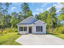 Charming single-story home featuring light siding, a black front door, and a well-maintained front yard at 3096 Hugo Rd., Conway, SC 29527