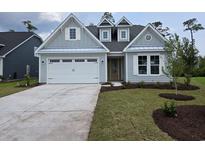 Charming home featuring a pristine two-car garage, fresh landscaping, and stylish architectural details at 712 Lapwind Loop, Myrtle Beach, SC 29579