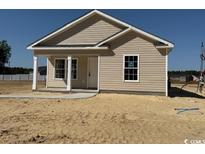 Tan vinyl siding home with covered porch and manicured, but unfinished, front yard at 8058 Mill Pond Rd., Galivants Ferry, SC 29544