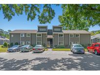 Two-story condo featuring gray siding, white trim, and parking spaces under a clear blue sky at 10301 N Kings Hwy. # 8-1, Myrtle Beach, SC 29572