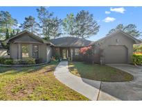 Charming one-story home boasts a well-manicured lawn, inviting walkway and attached garage at 111 Cedar Ridge Ln., Conway, SC 29526