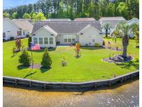 Well-manicured backyard with lush lawn, waterfront view, and mature trees at 1154 Lampwick Ln., Murrells Inlet, SC 29576