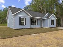 Charming one-story home featuring light blue siding, black shutters, and a neatly landscaped front yard at 3415 B And S Rd., Loris, SC 29569