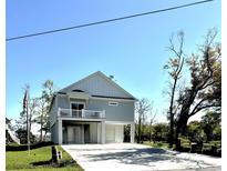 Coastal home featuring a spacious garage and an elevated living area with a charming white railed balcony at 400 Elizabeth Dr., Murrells Inlet, SC 29576