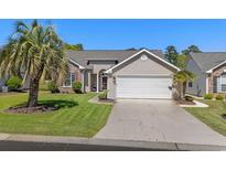 Charming home featuring a two-car garage, landscaped front yard, and inviting entryway at 4325 Deer Run Ave., Little River, SC 29566