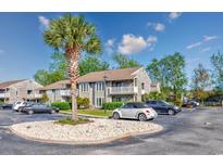 Condominium exterior showcasing maintained landscaping and a palm tree in the front with plenty of parking spaces at 4712 Cobblestone Dr. # K-7, Myrtle Beach, SC 29577