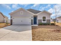Charming single-story home featuring a two-car garage, blue front door, and manicured front lawn at 500 Honeyhill Loop, Conway, SC 29526