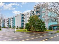 Apartment complex with blue and gray exterior, balconies, parking lot, and mature landscaping at 5001 Little River Rd. # 501E, Myrtle Beach, SC 29577