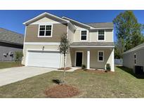 Two-story home featuring a two-car garage, neutral siding, and a neatly maintained front lawn at 605 Muster Field Ct., Conway, SC 29526