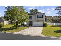 Charming two-story home featuring light siding, a well-manicured lawn, and an inviting driveway at 650 Woodman Dr., Conway, SC 29526