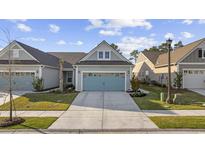 Charming home featuring a blue garage door, manicured lawn, and welcoming curb appeal at 6562 Torino Lane, Myrtle Beach, SC 29572