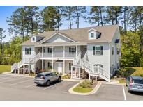 Charming two-story condo with white siding, black shutters, and well-manicured landscaping at 948 Jackline Place # 201, Murrells Inlet, SC 29576