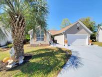 Charming single-story home with a well-manicured lawn, a two-car garage, and beautiful palm tree in the front yard at 2488 Oriole Dr., Murrells Inlet, SC 29576