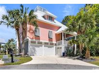 Stunning home featuring tropical landscaping, a large driveway, and a multi-car garage with ample parking at 4240 Highway 17 Business, Murrells Inlet, SC 29576