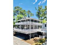 Stunning two-story home featuring double decks with white railings and lush greenery at 6001 - 1322 S Kings Hwy., Myrtle Beach, SC 29575
