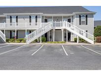 Two-story condo complex featuring white staircases, neutral siding, black shutters, and ample parking at 155 Westhaven Dr. # 14D, Myrtle Beach, SC 29579