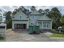 A two-story home with an attached garage under construction, and a dumpster in front at 2611 Painted Trillium Ct., Myrtle Beach, SC 29579